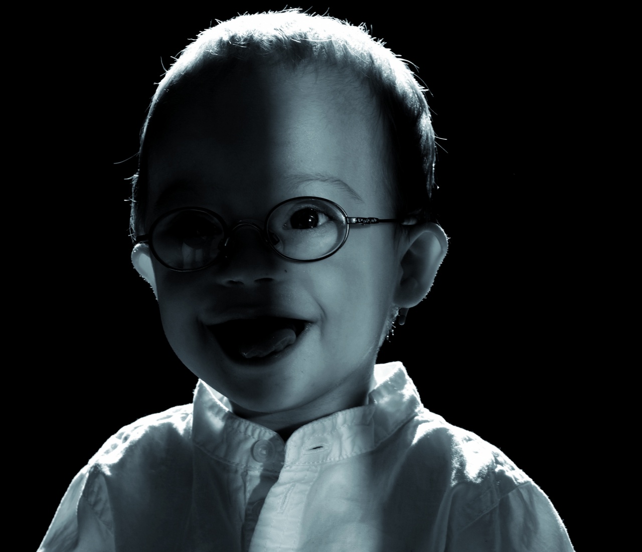 Schwarz-weiß Portrait von Matteo, er lacht und hat eine Brille an