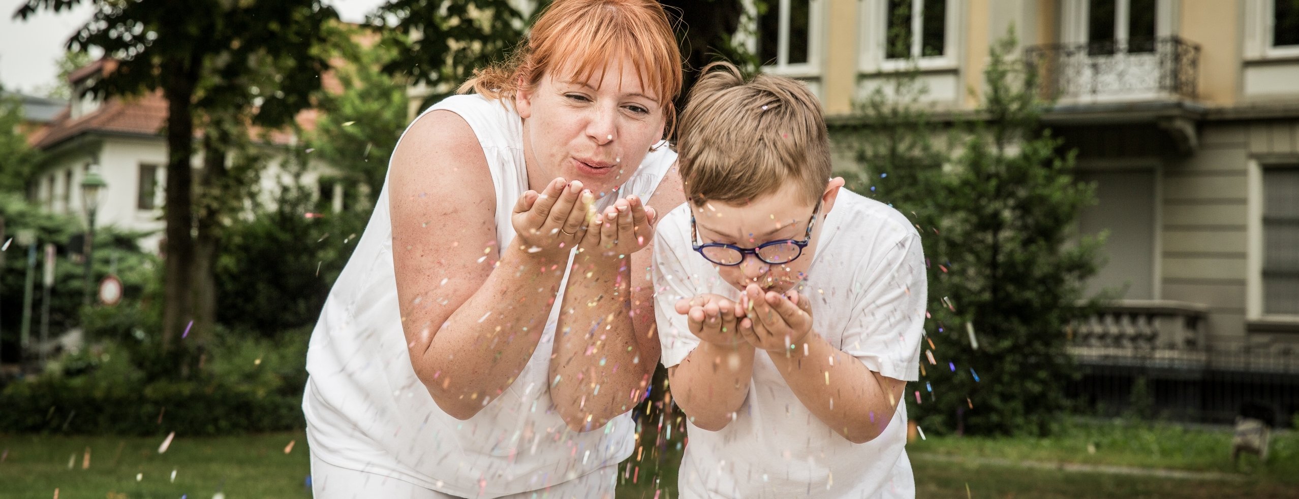 Mutter und Sohn freuen sich über herabregnendes Konfetti.