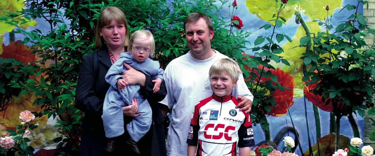 Eine Familie mit einem Sohn und einer kleinen Tochter mit Down-Syndrom