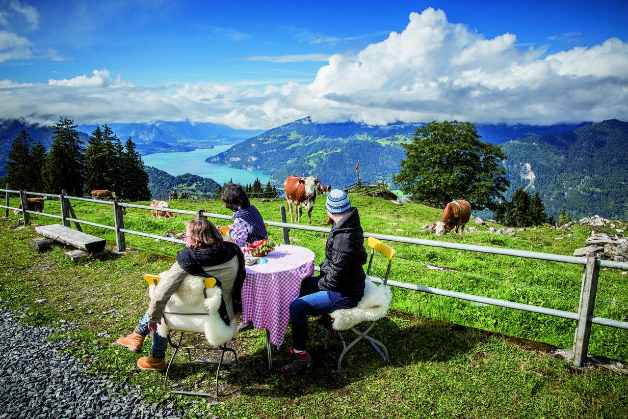 3 Ohrenkuss-Autoren sitzen warm angezogen an einem Tisch und genießen die Aussicht der Schweizer Berge.