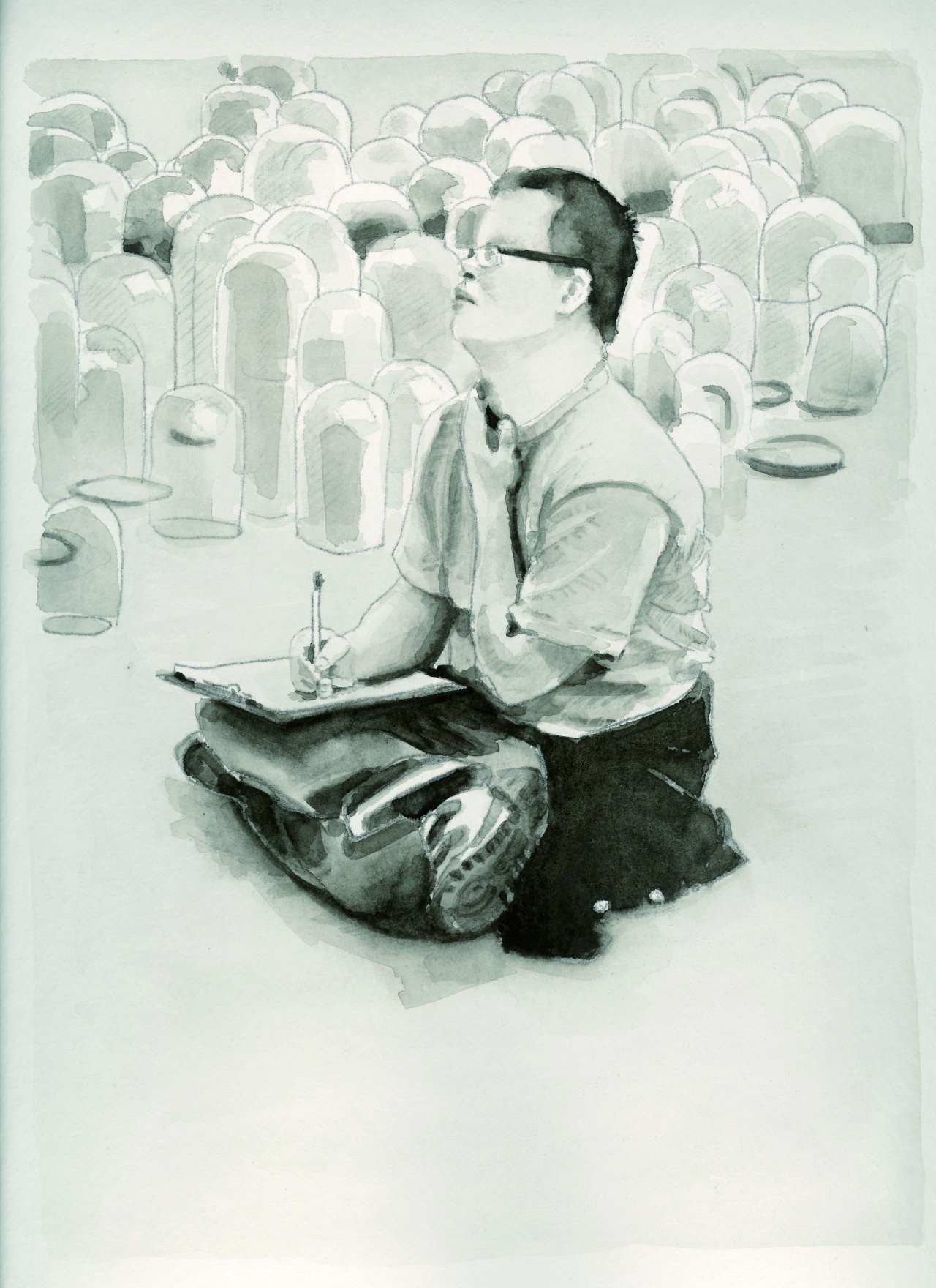 Dominic Edler sitzt im Schneidersitz vor einem Kunstwerk im Museum mit Block und Stift auf den Knien.
